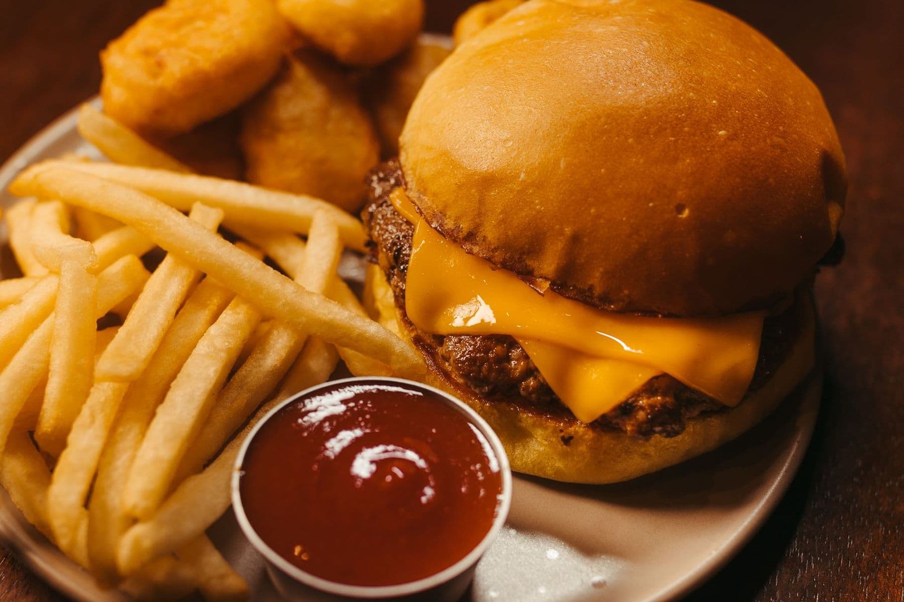 Beef burger with a side of fries and dipping sauce